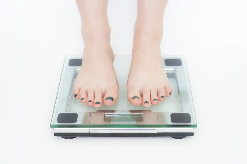 Bare feet standing on a glass bathroom scale